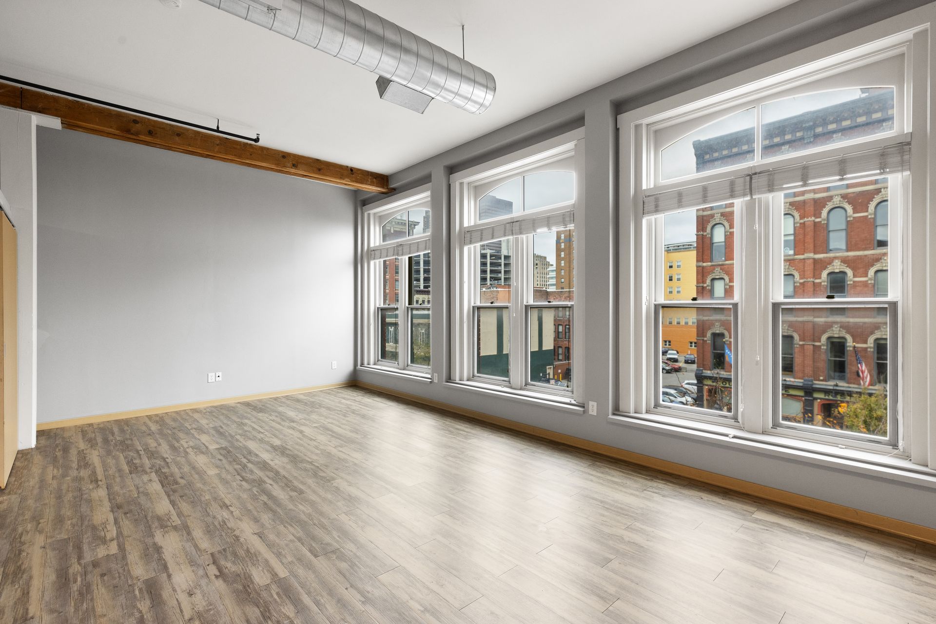 an empty room with a lot of windows and a wooden floor .