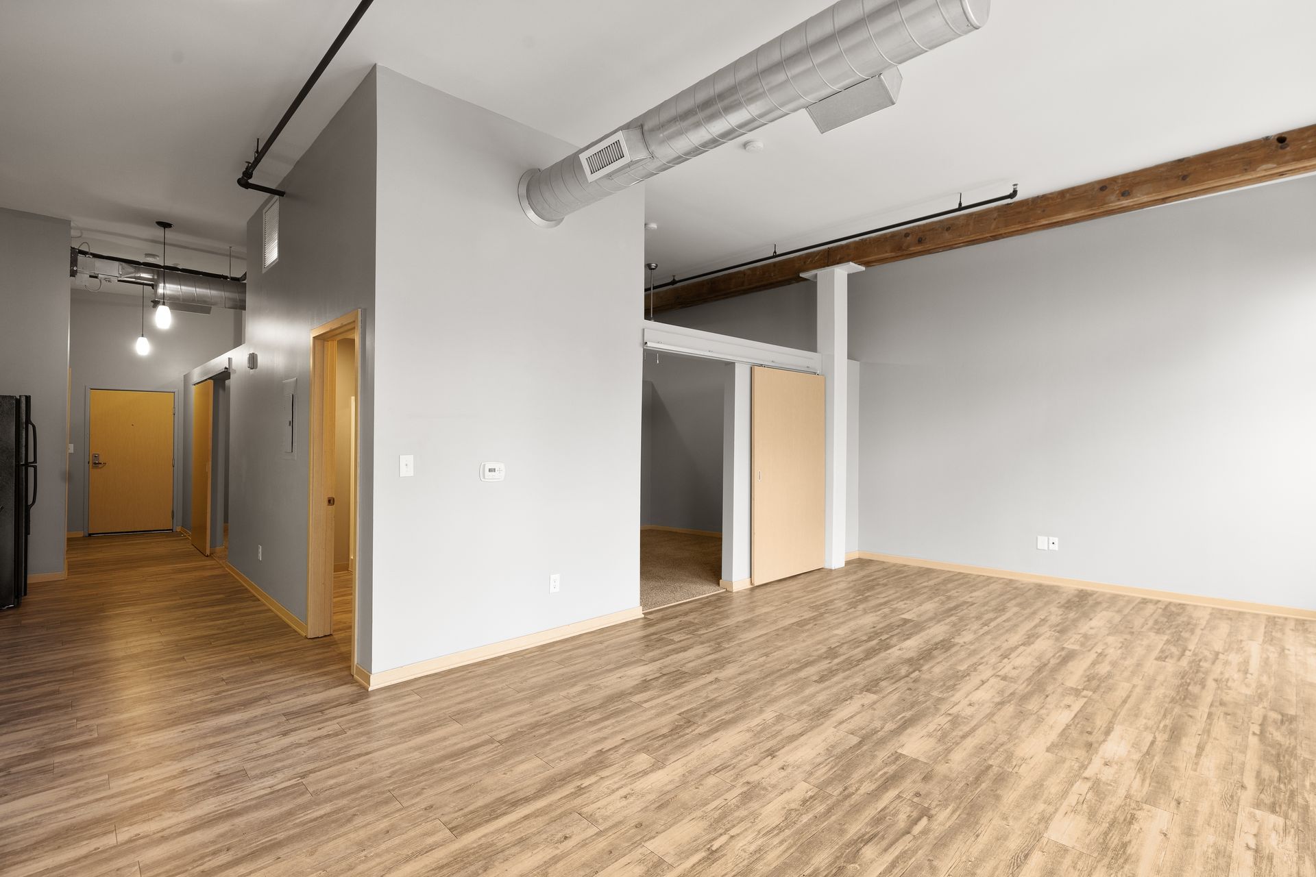 a large empty room with hardwood floors and gray walls .