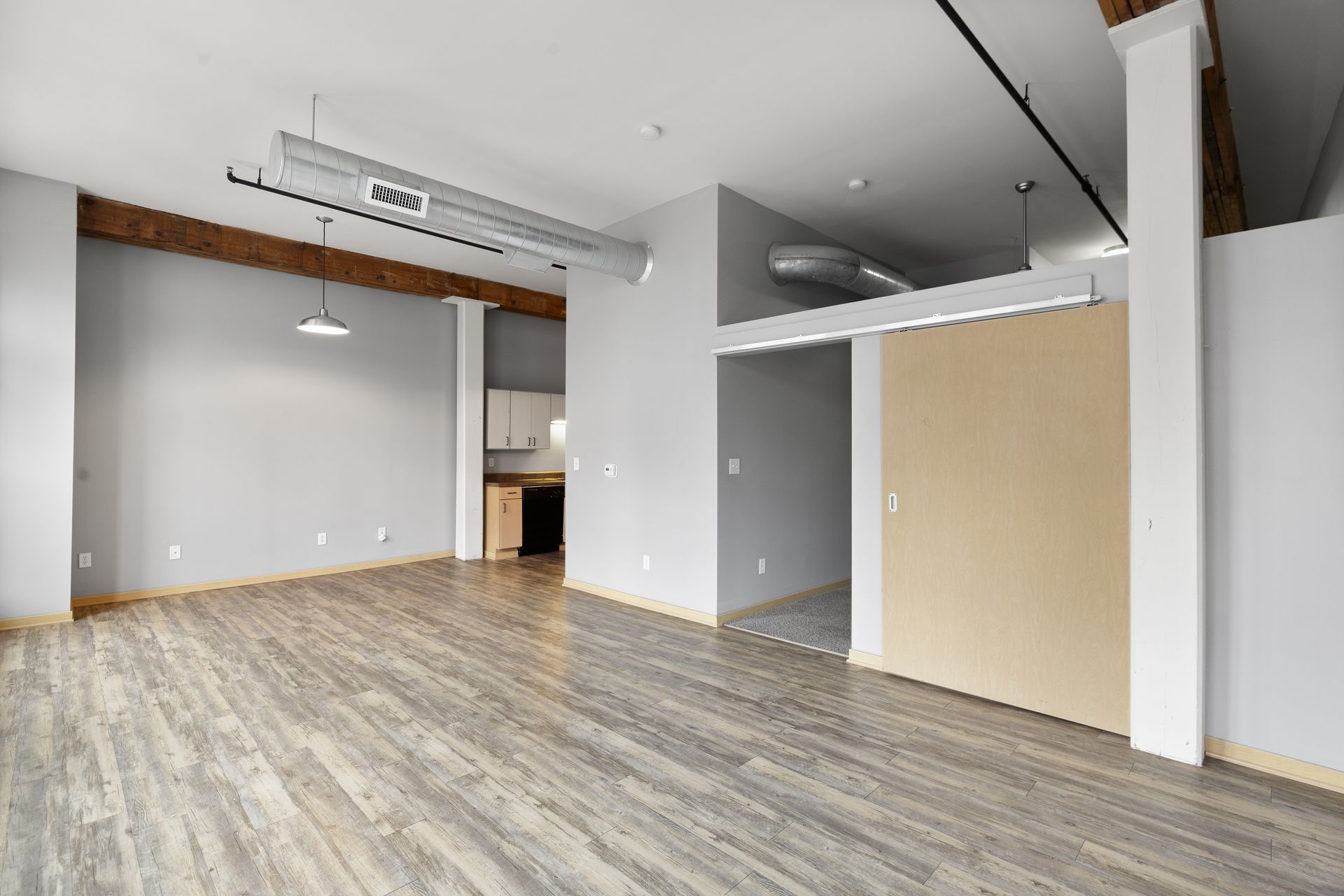 a large empty room with hardwood floors and sliding doors .