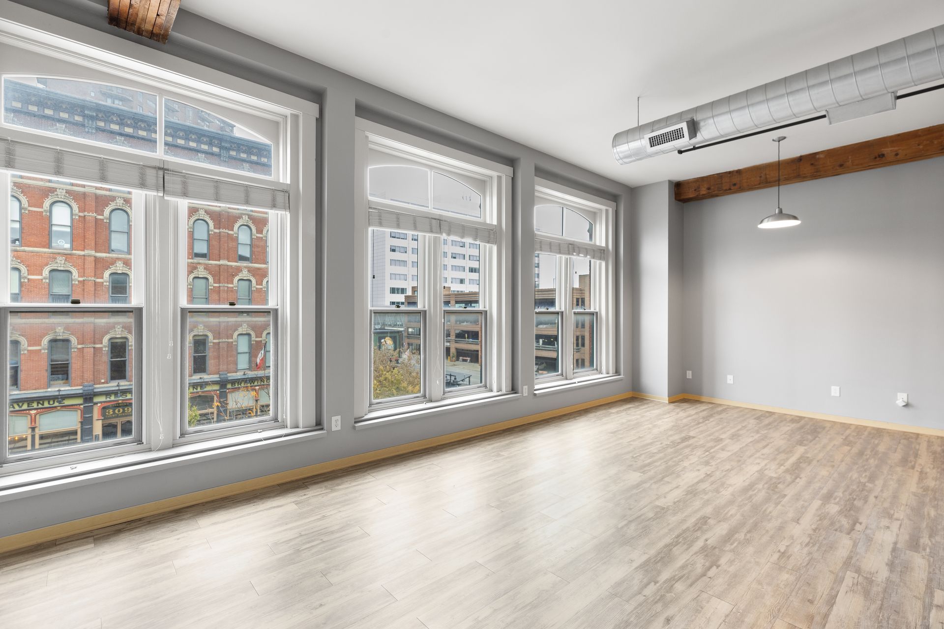 an empty room with a lot of windows and a wooden floor .