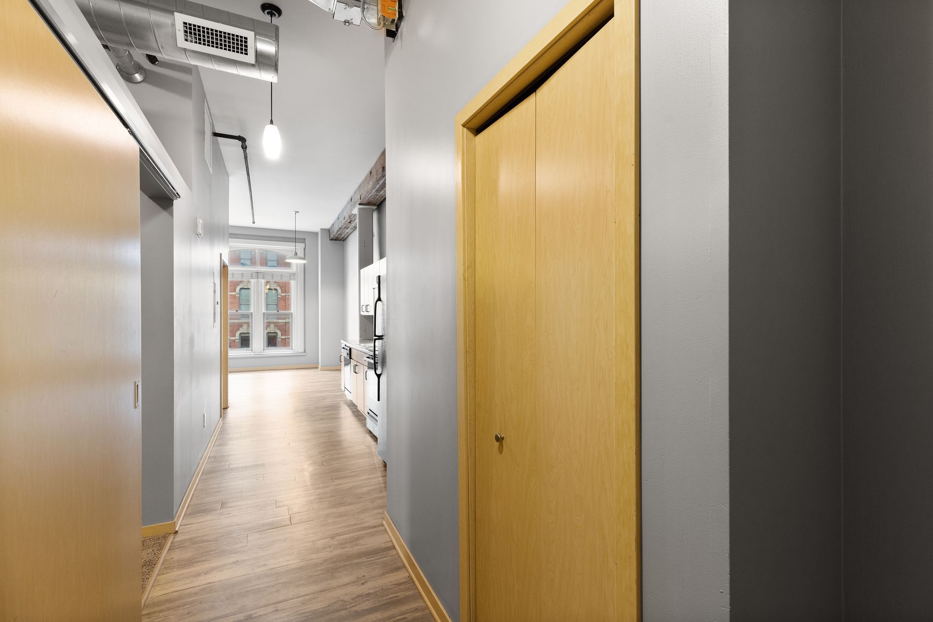 a long hallway with wooden floors and gray walls .