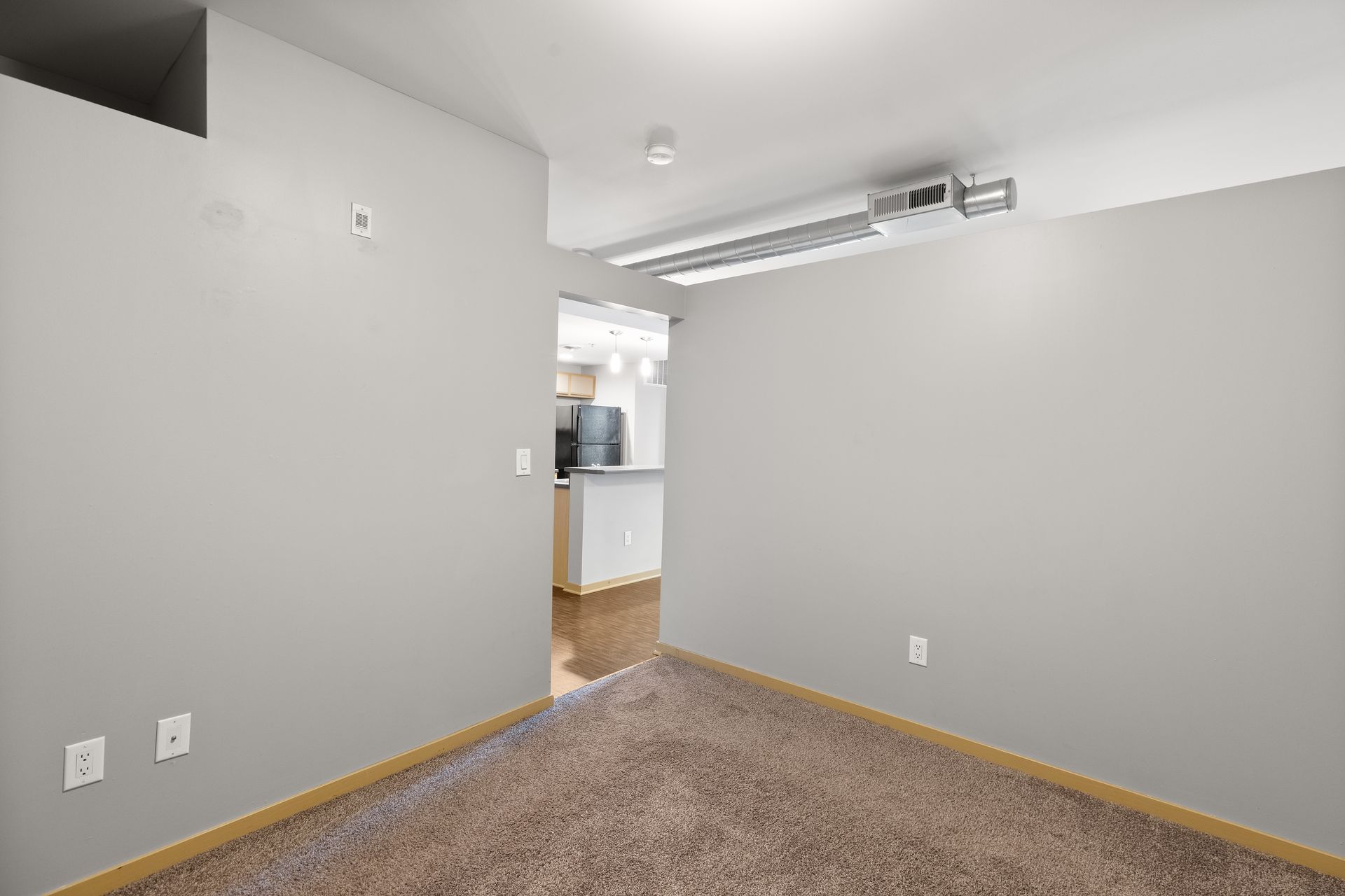 an empty room with a carpeted floor and a ceiling fan .