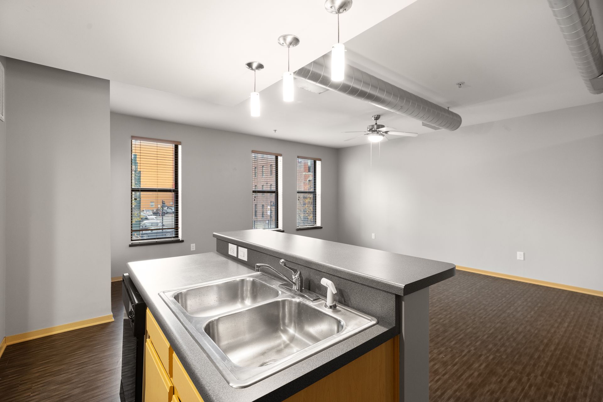 an empty kitchen with two sinks and a ceiling fan