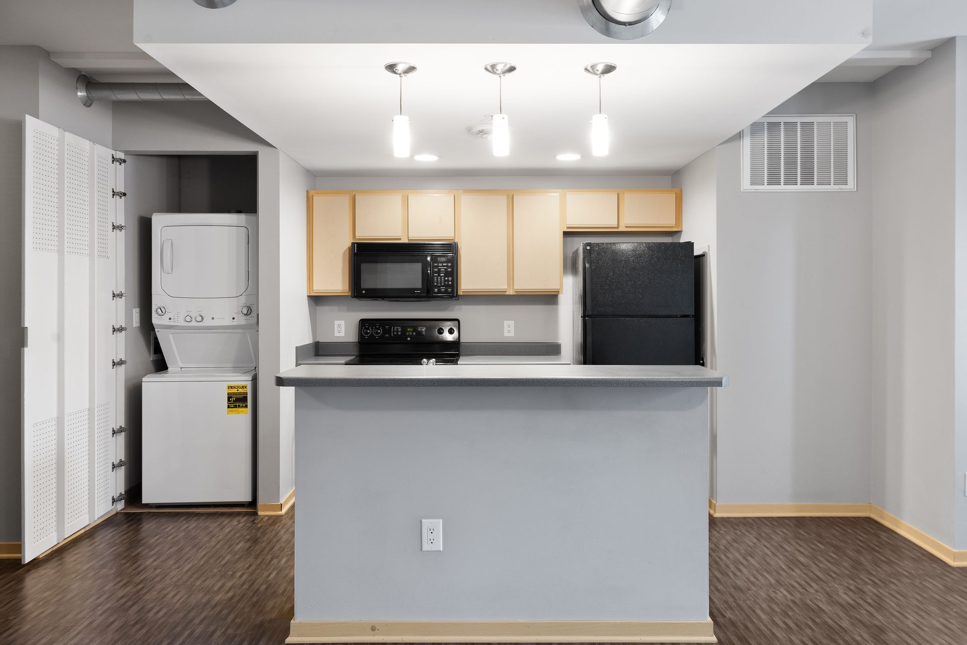 a kitchen with a refrigerator , stove , microwave , and dryer .