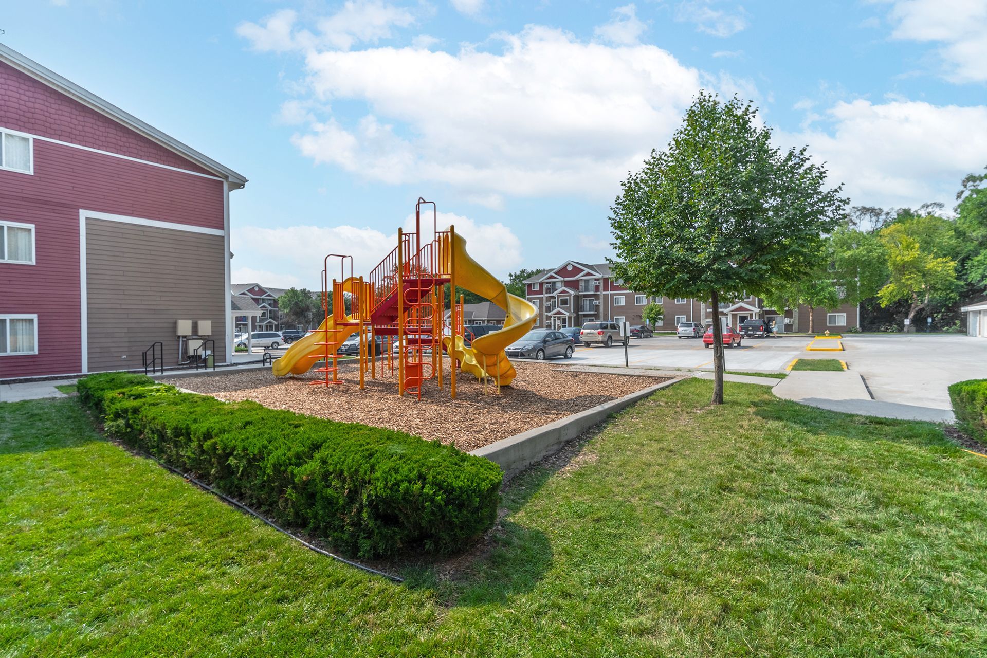 there is a playground in the middle of a lush green park .