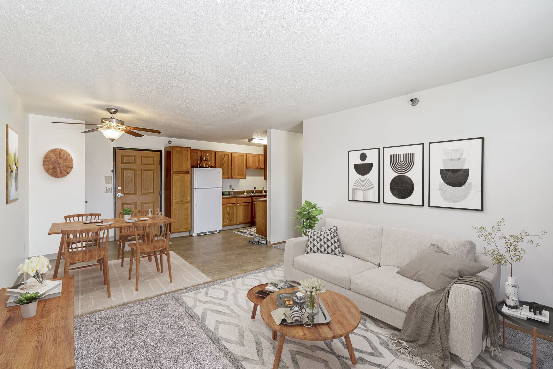 a living room with a couch , table , chairs and a ceiling fan .