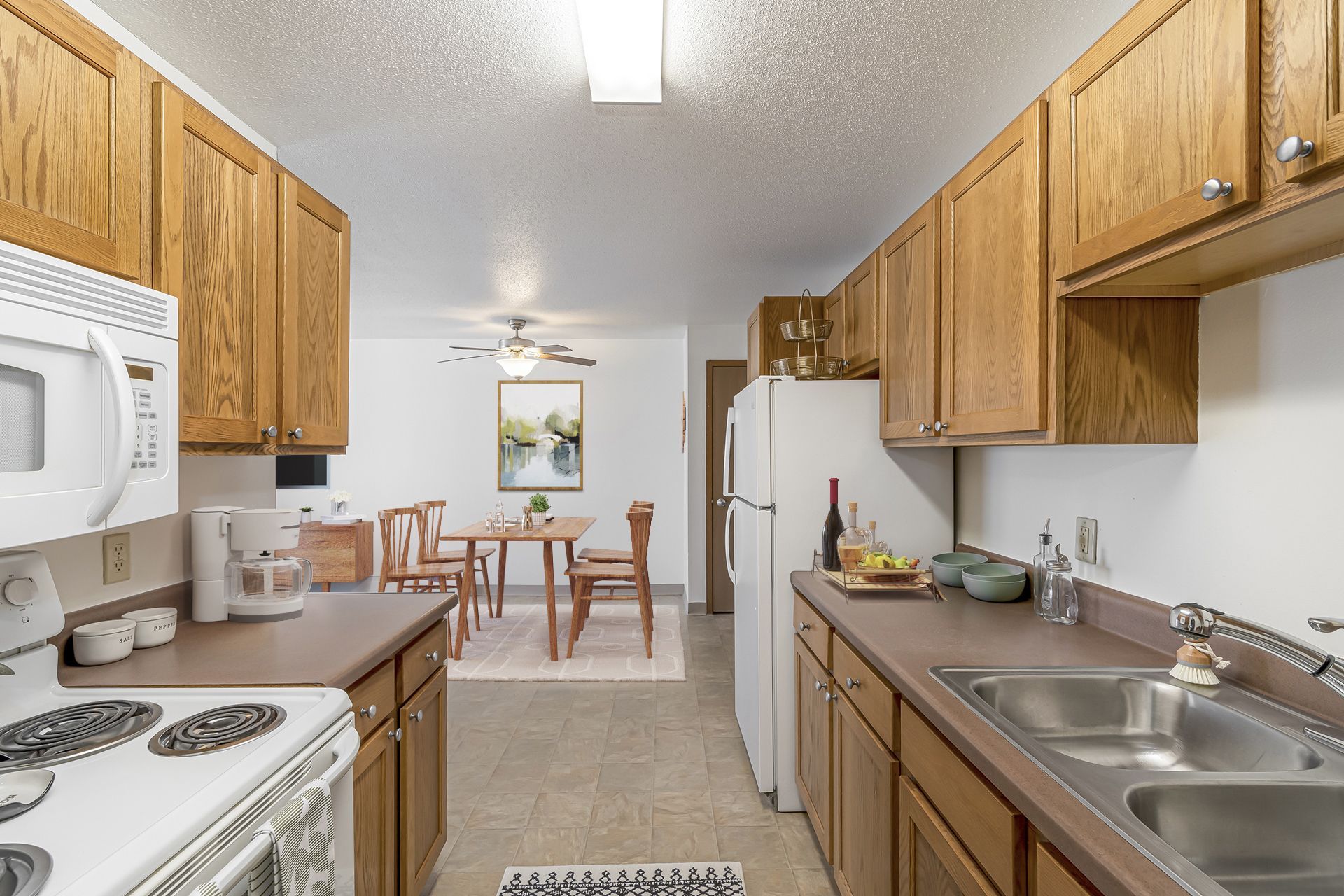 a kitchen with a stove , sink , microwave and refrigerator