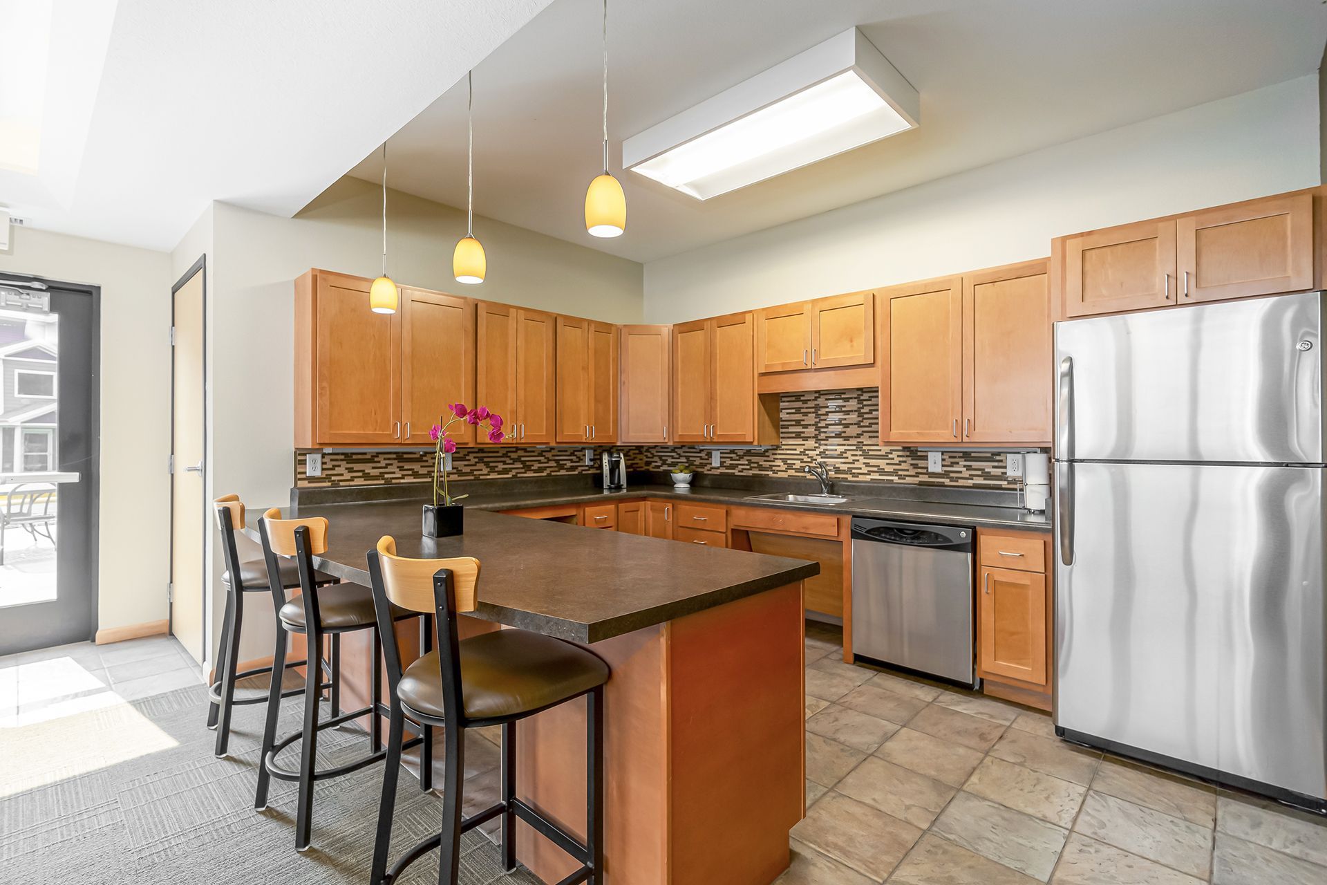 a kitchen with stainless steel appliances and wooden cabinets .
