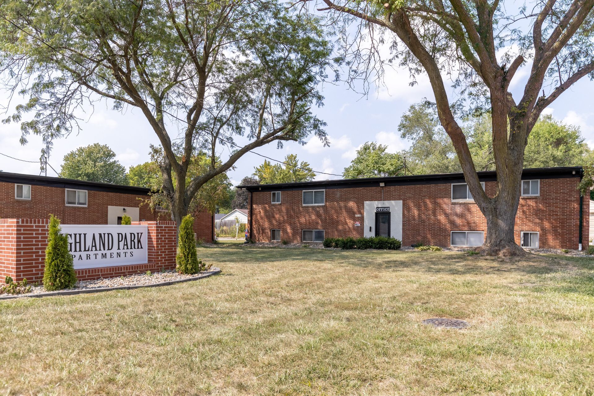 a brick apartment building with a sign in front of it .