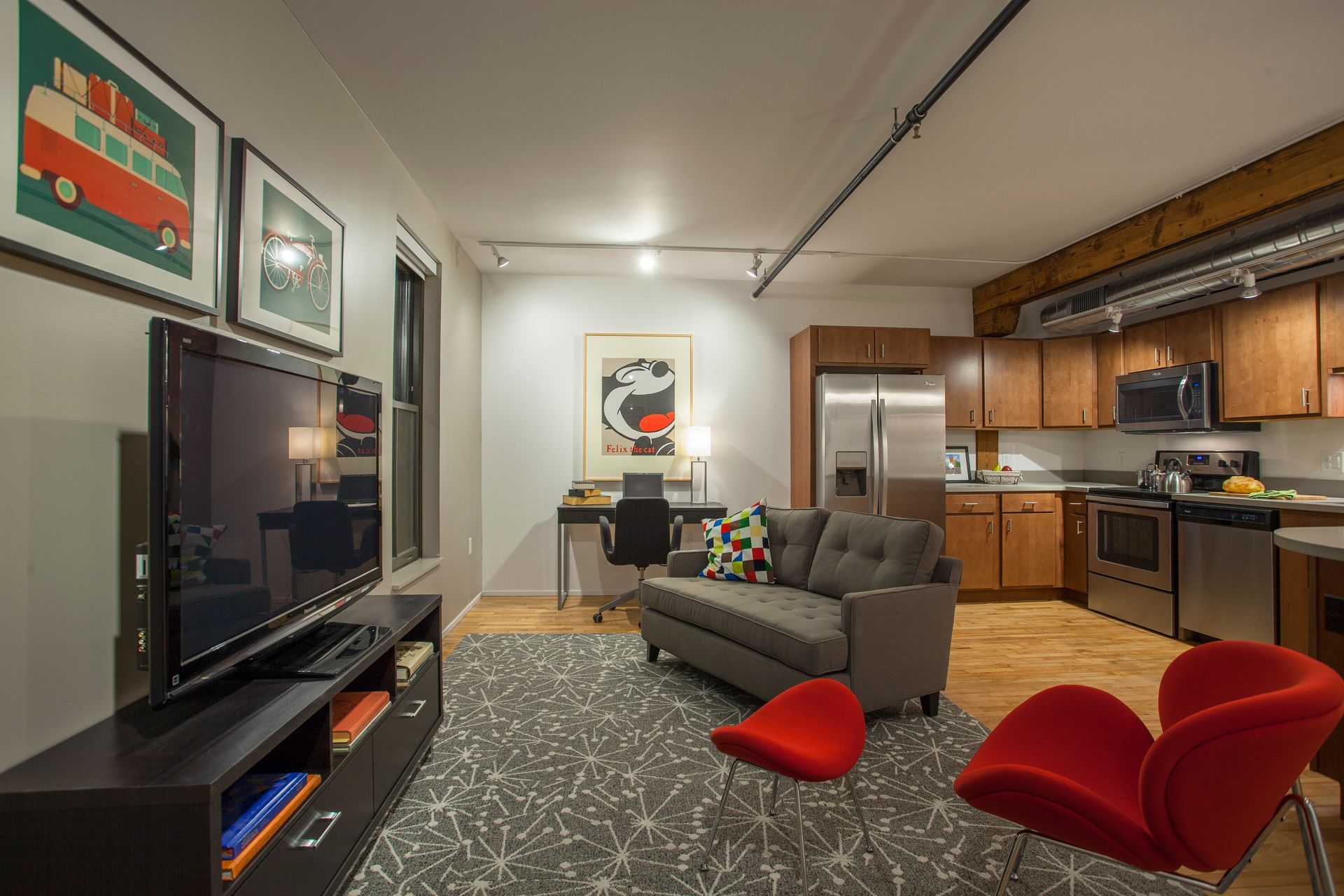 a living room with a couch , chairs , and a flat screen tv .
