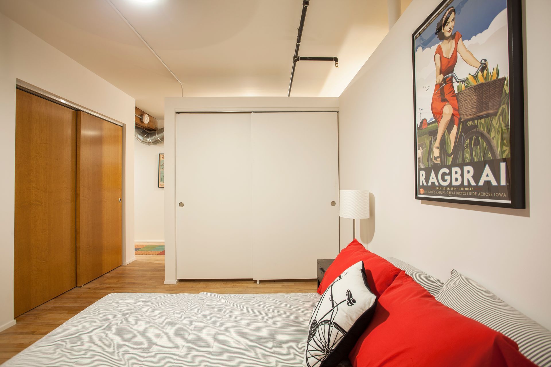 a bedroom with a large bed and a poster on the wall that says ragbrai