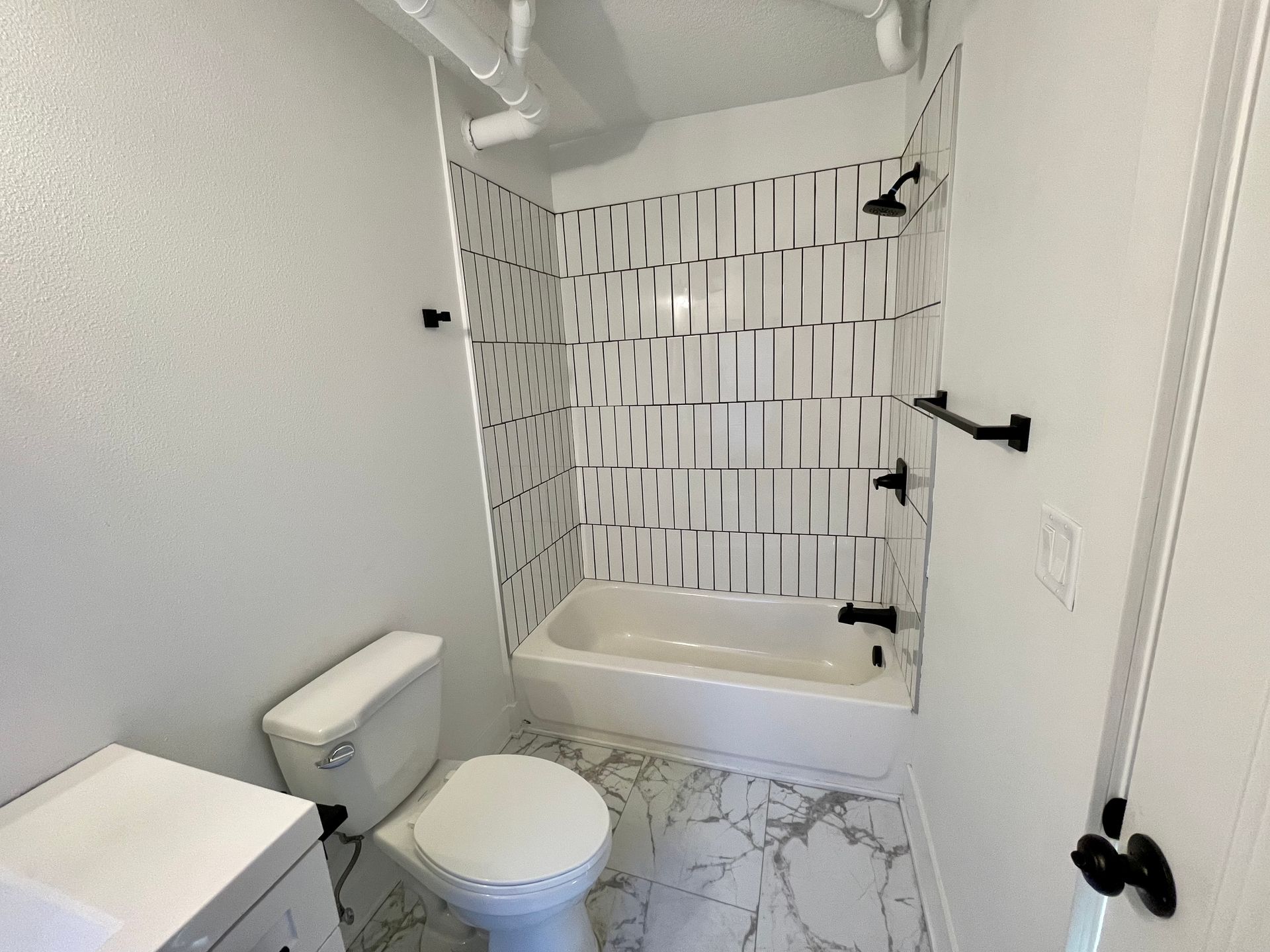a bathroom with a toilet , sink and bathtub .