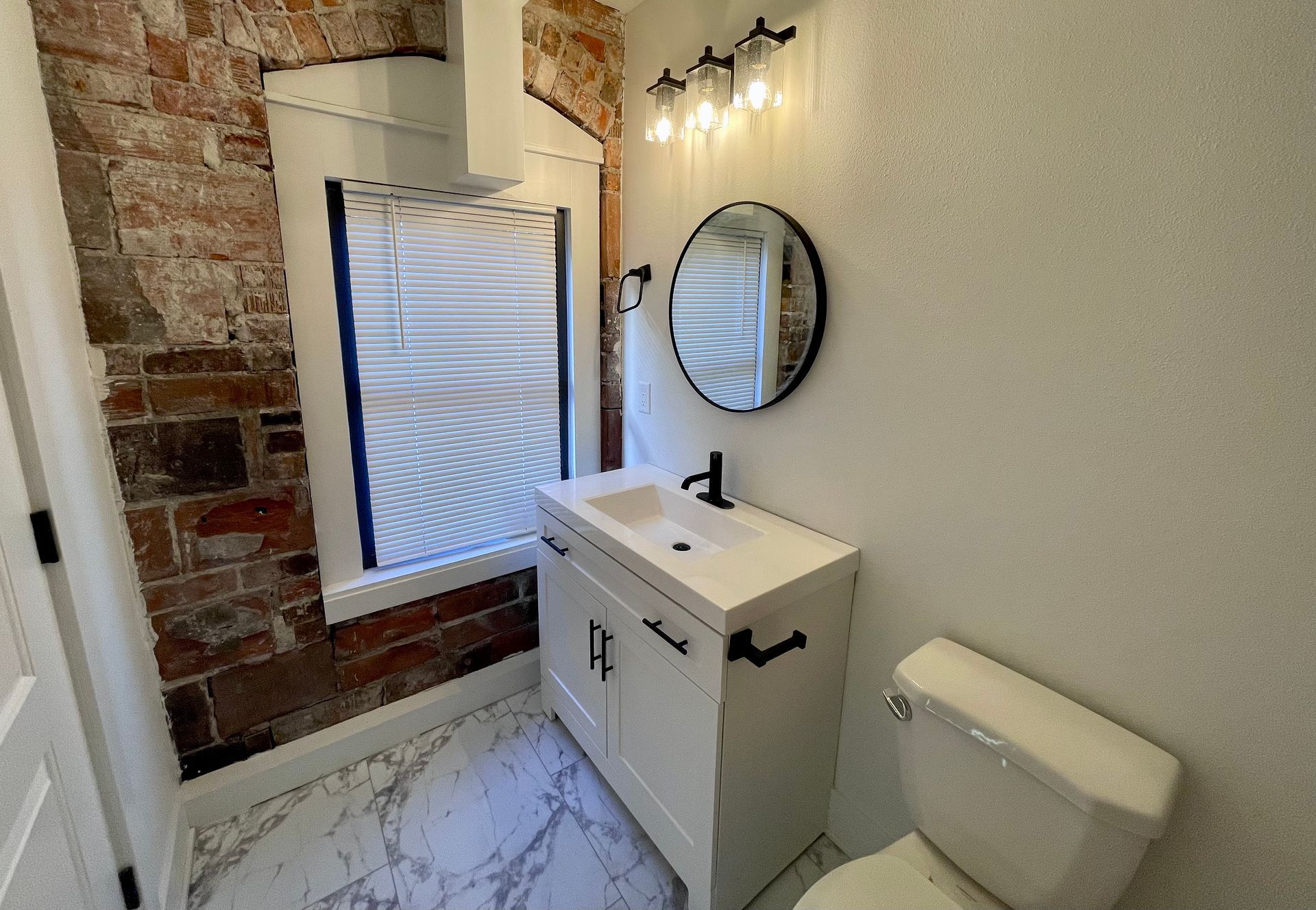 a bathroom with a toilet , sink and mirror .