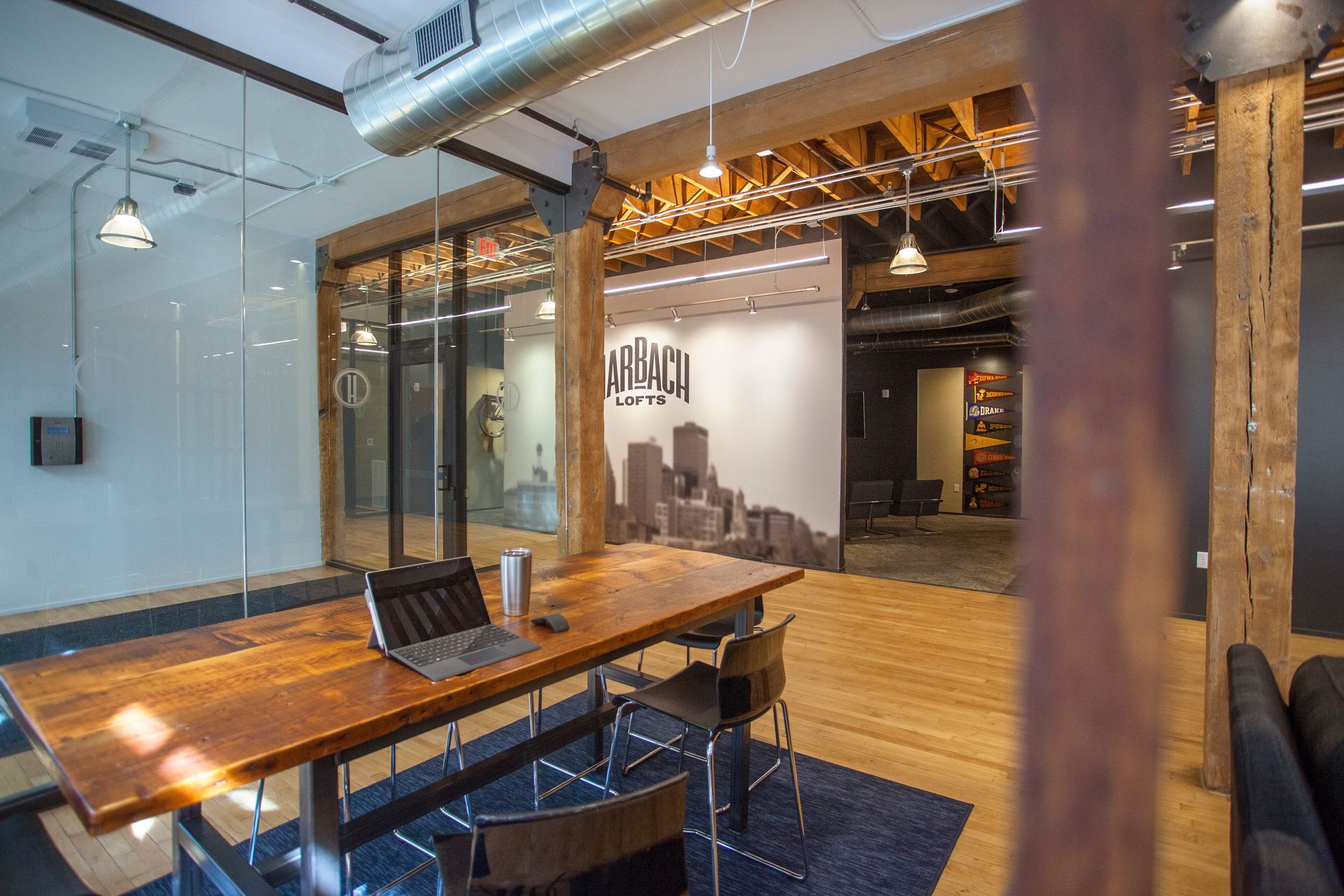 a conference room with a wooden table and chairs and a laptop on it .