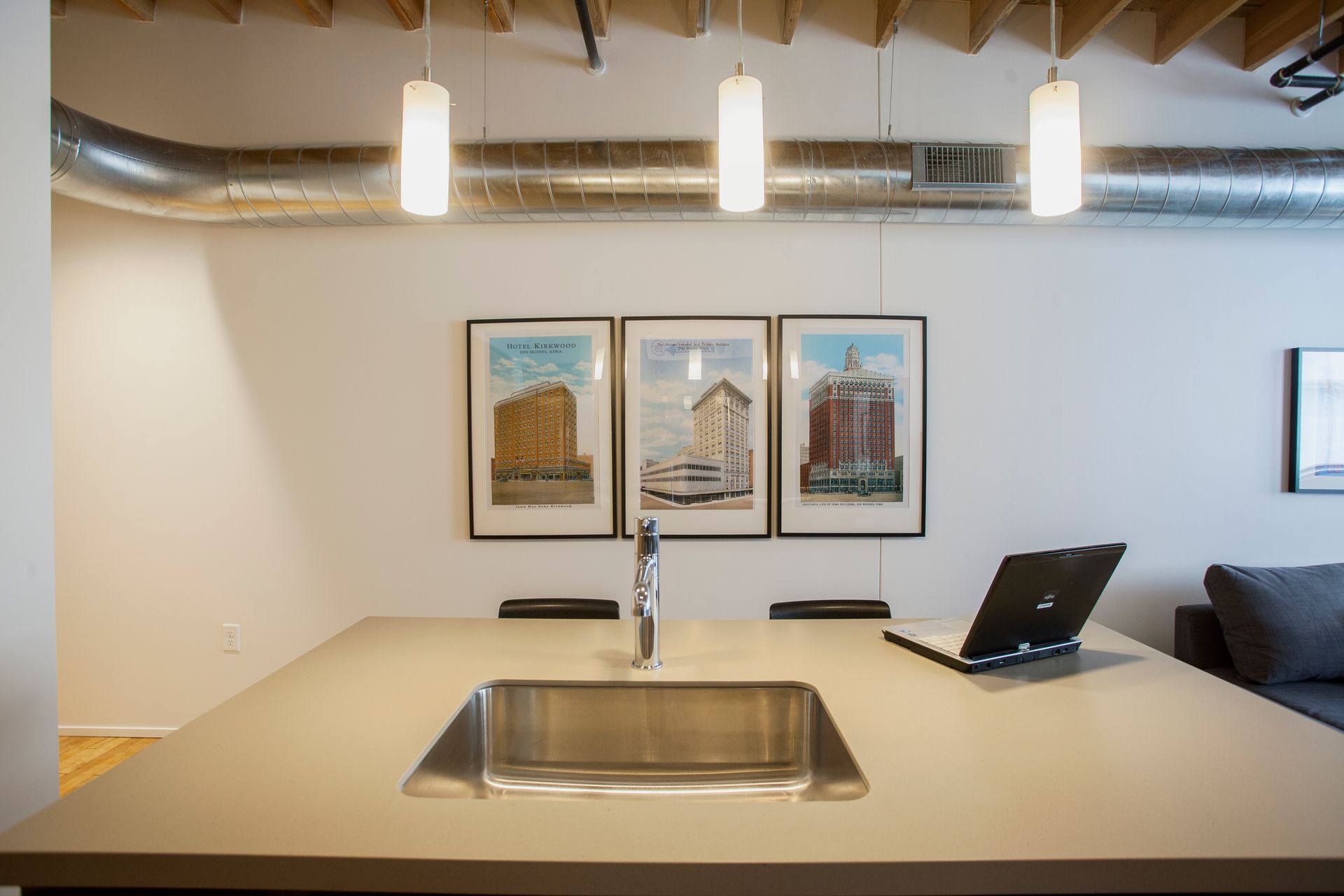 a kitchen with a sink and a laptop on the counter