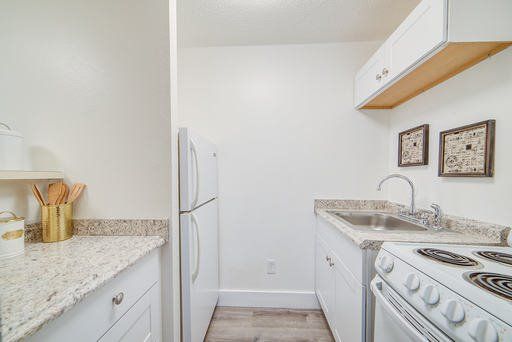 a kitchen with a refrigerator , stove , sink , and cabinets .