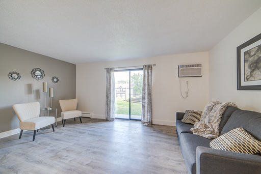 a living room with a couch , chairs , and a sliding glass door .