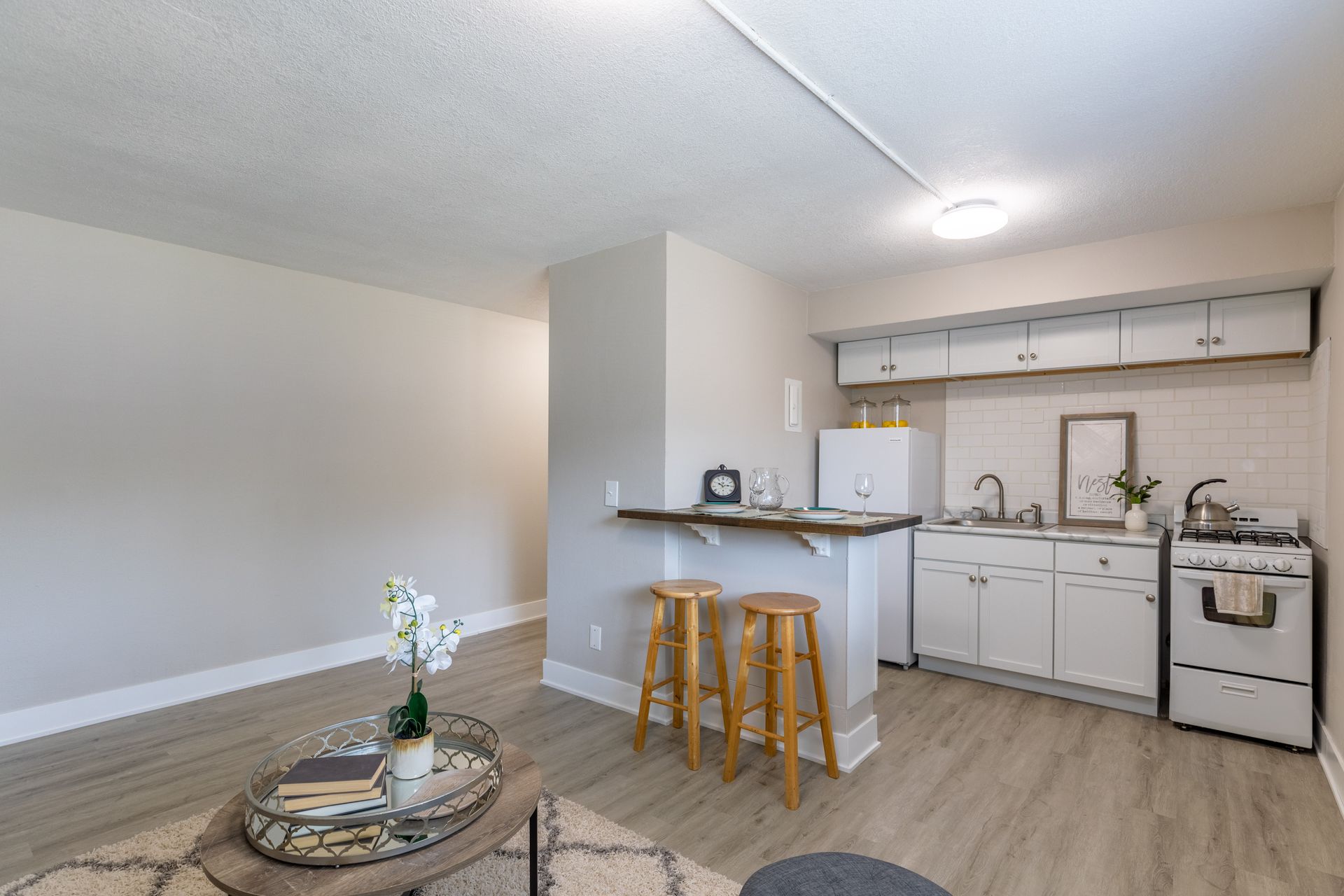 a living room with a kitchen and a coffee table