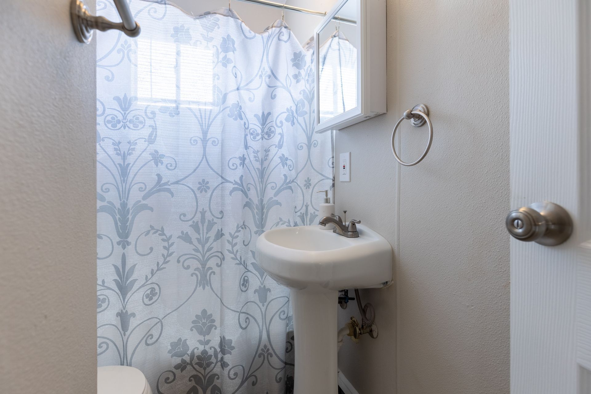 a bathroom with a sink , toilet and shower curtain .