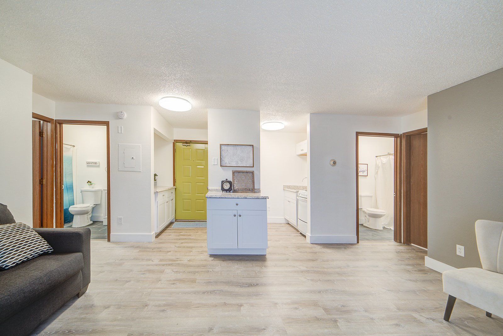 a living room with a couch , chair , and kitchen .