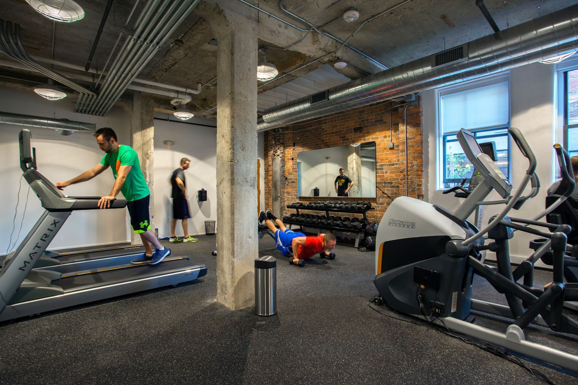 a man is running on a treadmill in a gym .