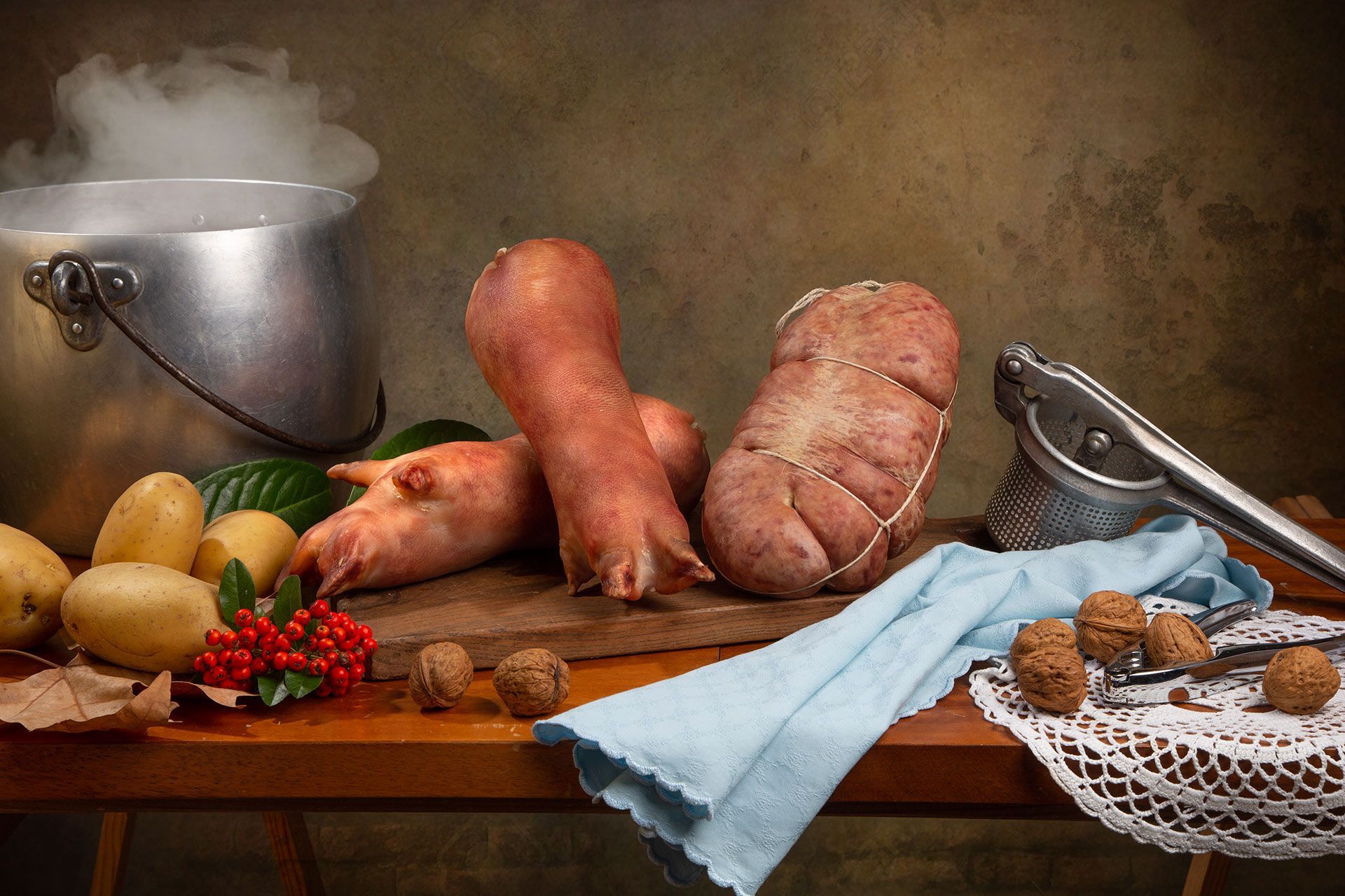 Un tavolo con sopra patate, noci e una pentola di acqua bollente.