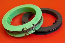 Two spools of thread are laid on top of each other on a red surface.