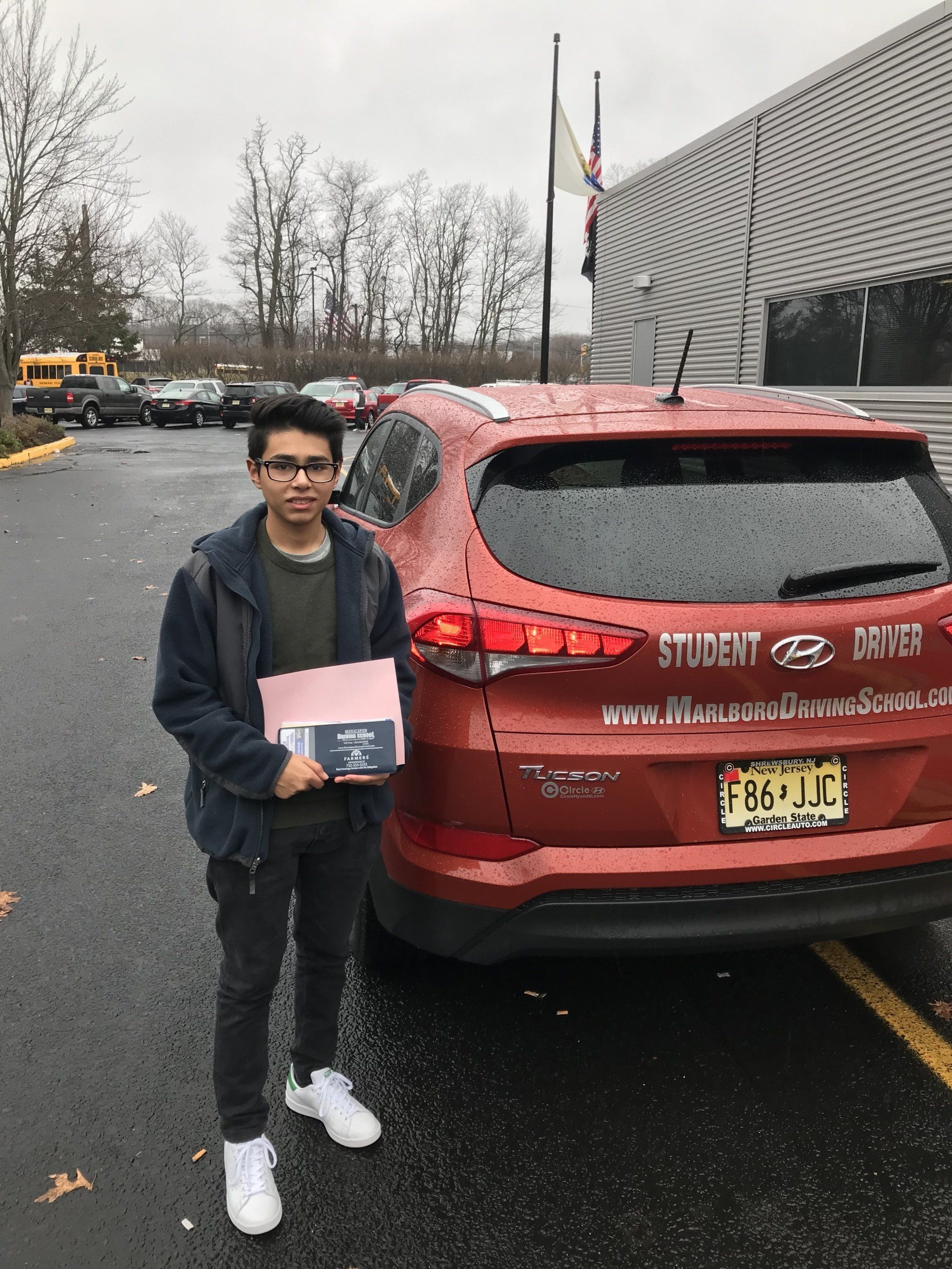 Male Student Holding Certificate Besides The Car — Morganville, NJ — Marlboro Driving School