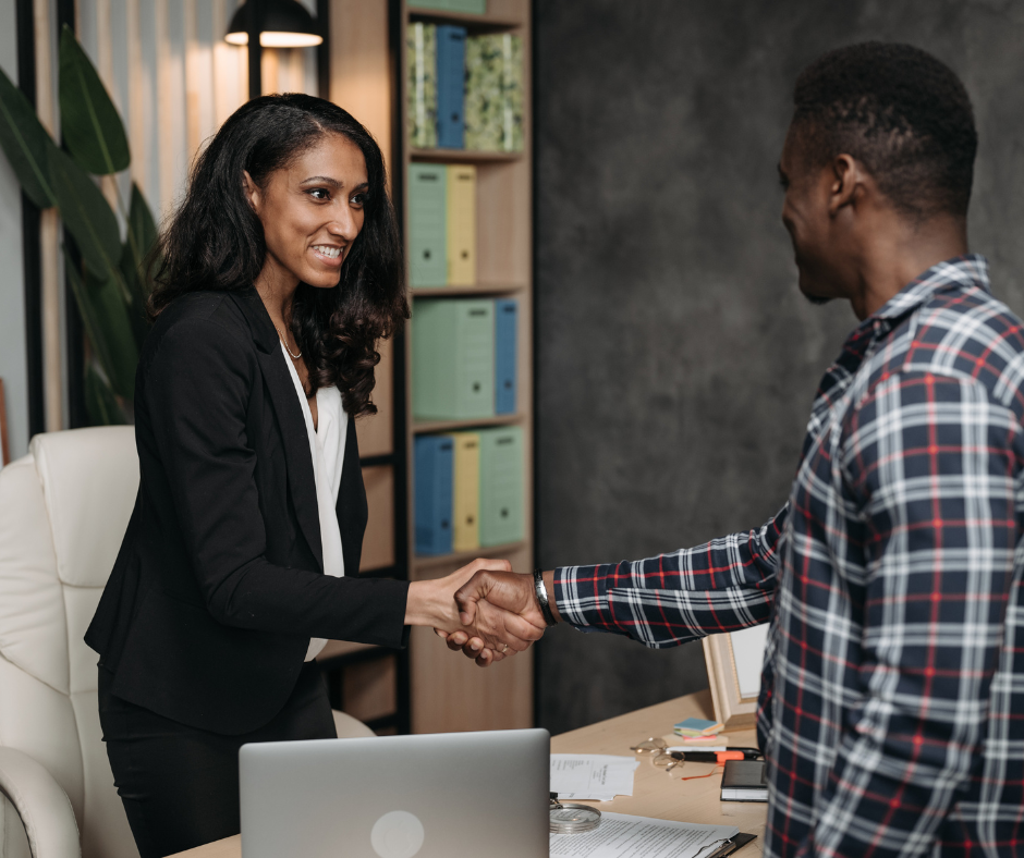 Une femme serre la main d'un homme dans un bureau.