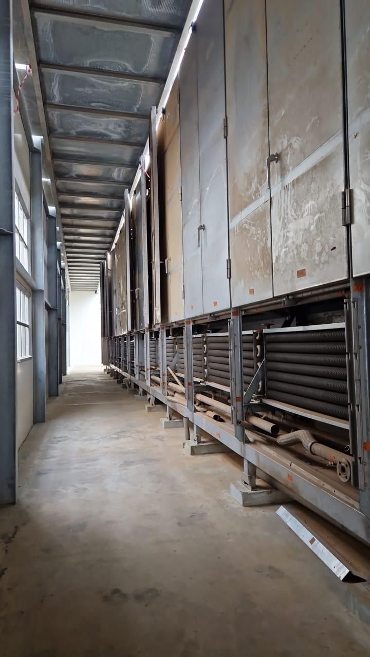 Un long couloir dans un bâtiment avec beaucoup de tuyaux.