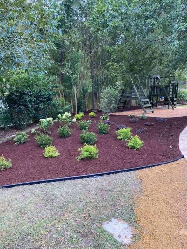 A backyard with a playground and a lot of mulch.