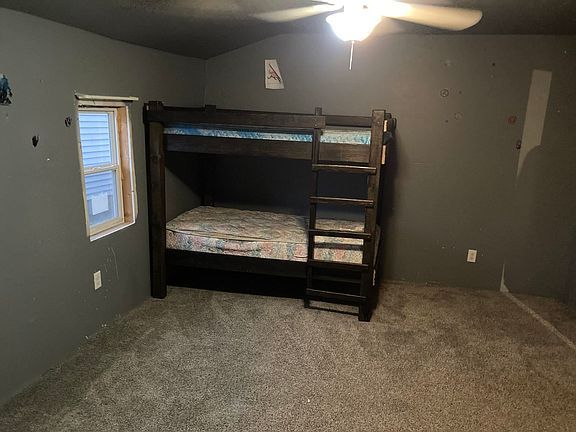 A bedroom with bunk beds and a ceiling fan