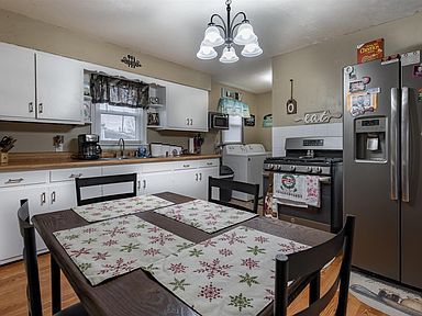 A kitchen with a table and chairs and a refrigerator.