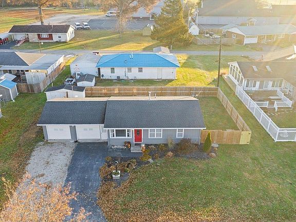 An aerial view of a house with a blue roof in a residential area.