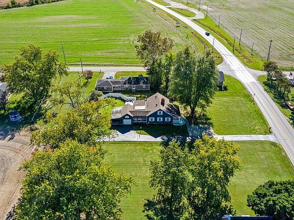 An aerial view of a house in the middle of a lush green field.