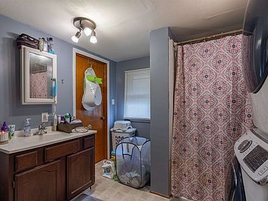 A bathroom with a sink and a shower curtain.