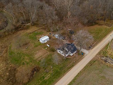 An aerial view of a house and a dirt road.