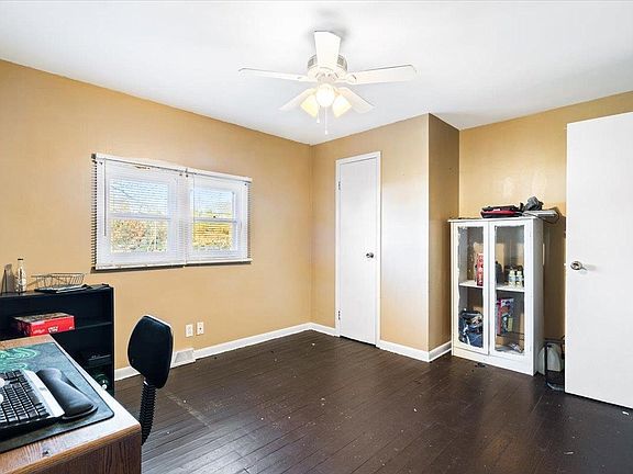 There is a ceiling fan in the room with a desk and chair.