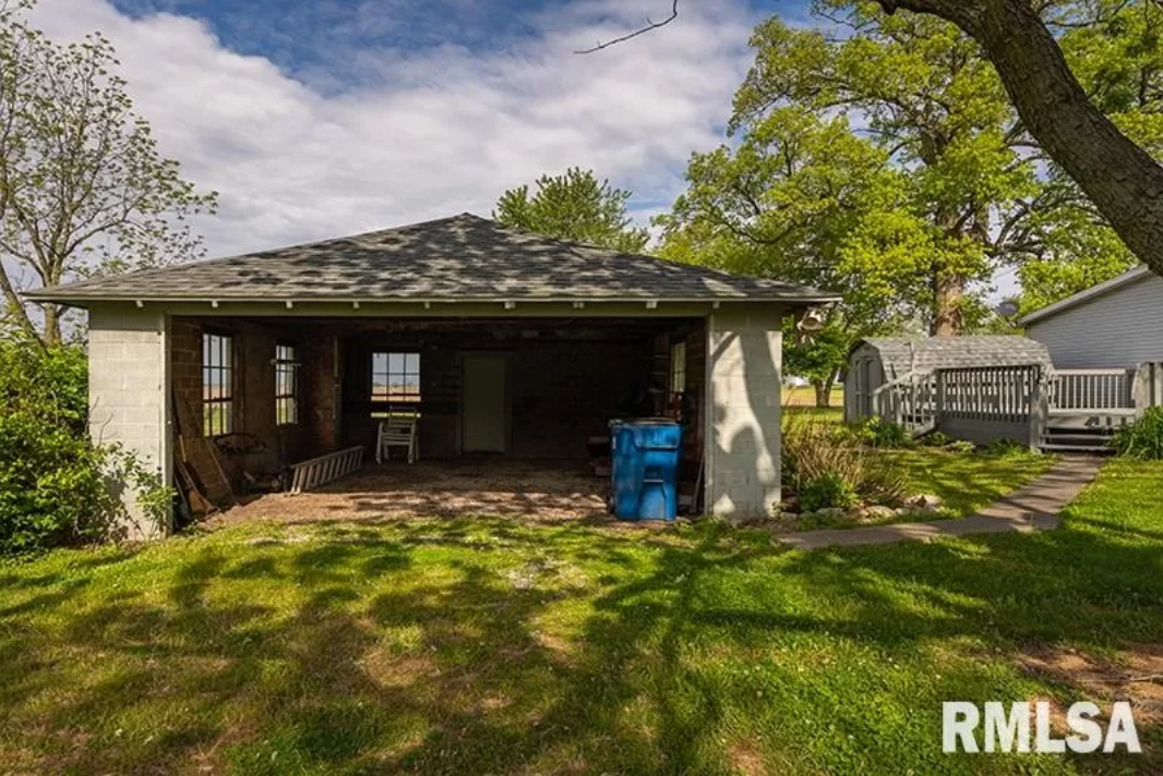 The backyard of a house with a garage and a shed.