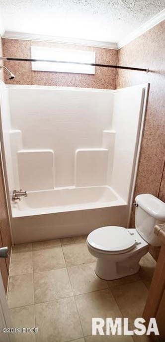 A bathroom with a toilet , tub and shower.