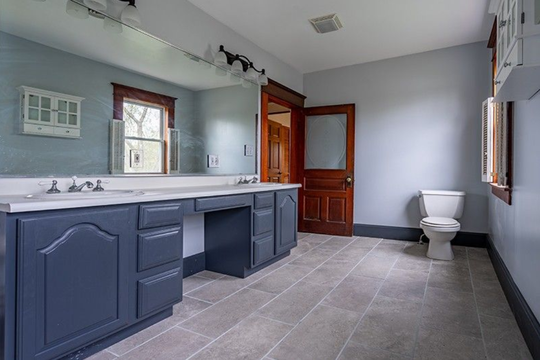 A bathroom with a toilet , sink and mirror.