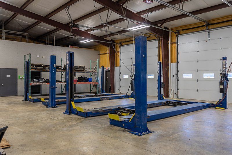 A garage with a lot of lifts and a garage door.