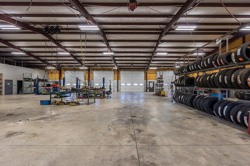 A large warehouse filled with lots of tires and a garage door.