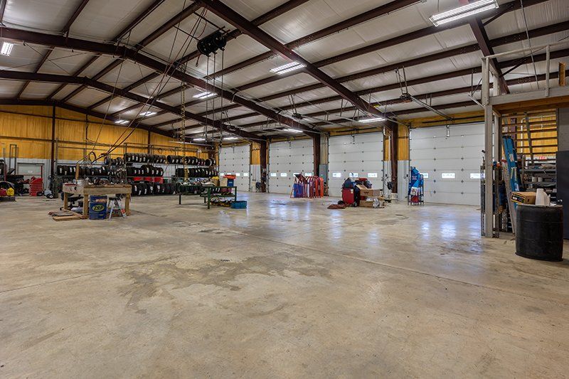 A large warehouse with a lot of doors and a concrete floor.