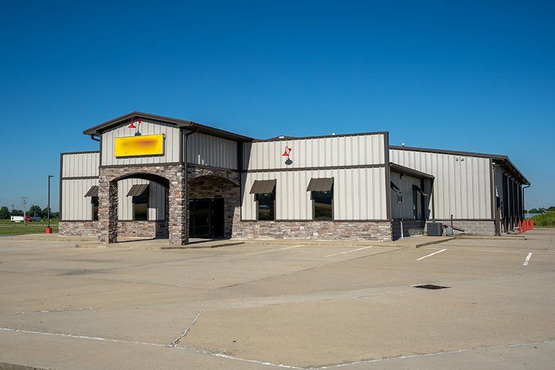 A large building with a lot of windows and a parking lot in front of it.