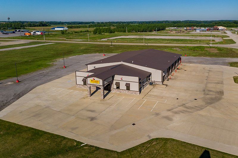 An aerial view of a large building in the middle of a field.
