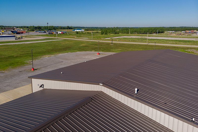 An aerial view of a large building with a brown metal roof.