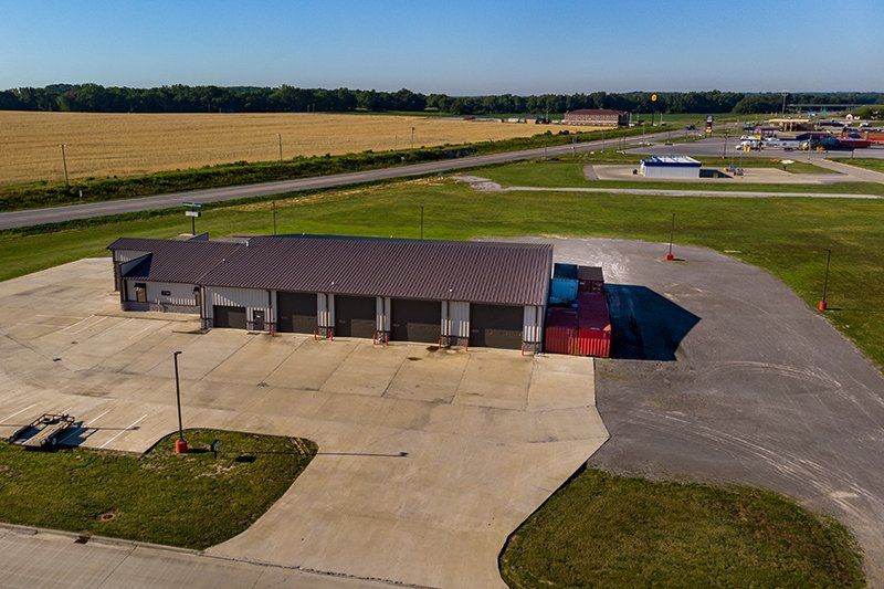 An aerial view of a large building in the middle of a field.