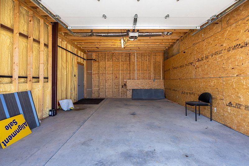 An empty garage with a chair and a sign on the wall.