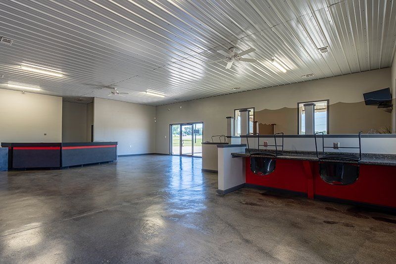 A large empty room with a red counter and a white ceiling.